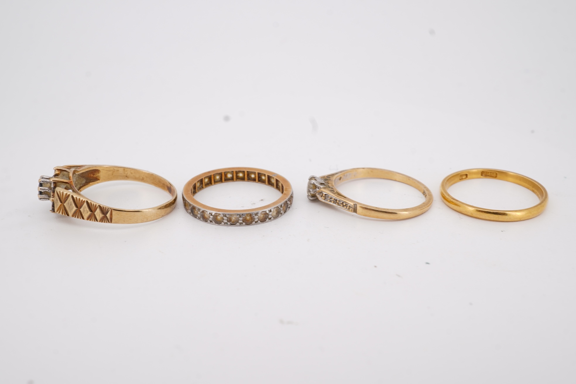 A 22ct wedding band, size M, 2 grams, an 18ct, plat and single stone diamond ring, a a modern 9ct gold, sapphire and diamond cluster ring and a yellow metal and white stone, eternity ring.